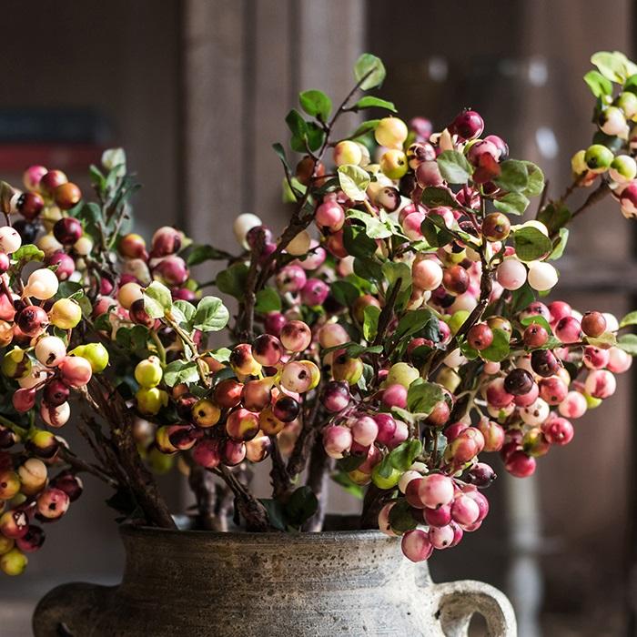 A vibrant artificial berry stem featuring yellow and red berries, standing 17 inches tall, perfect for home decor.