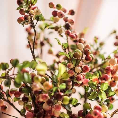 A vibrant artificial berry stem featuring yellow and red berries, standing 17 inches tall, perfect for home decor.