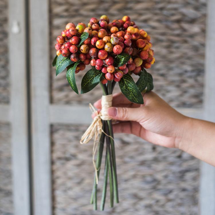 A vibrant 11-inch tall artificial fruit berry bunch featuring orange, red, and green colors, perfect for home and wedding decor.