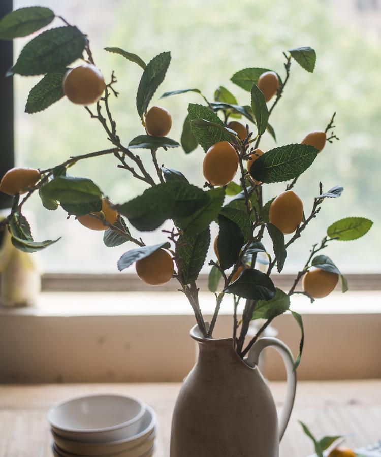 A 39-inch tall artificial lemon stem featuring eight vibrant silk lemons in green and yellow colors, perfect for home decor.