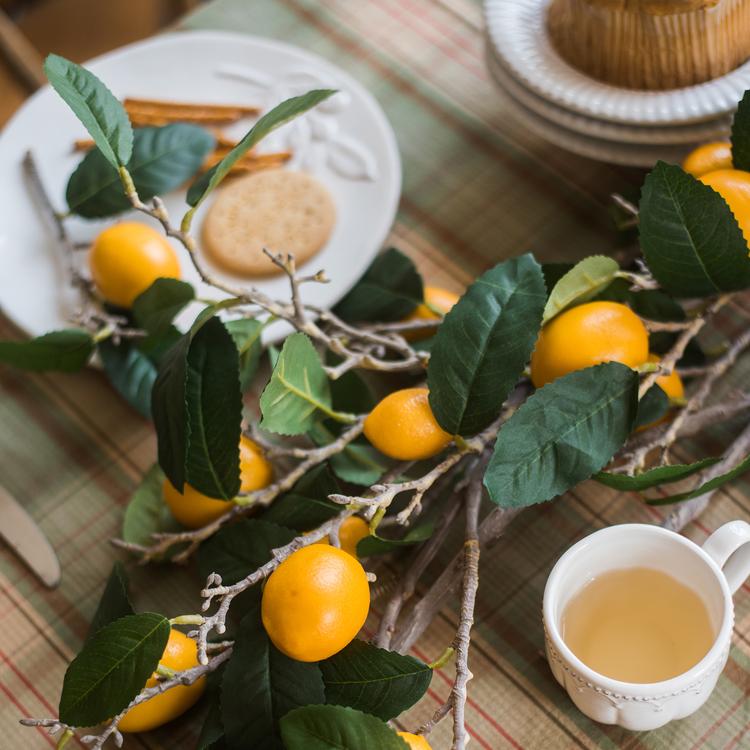 A 39-inch tall artificial lemon stem featuring eight vibrant silk lemons in green and yellow colors, perfect for home decor.