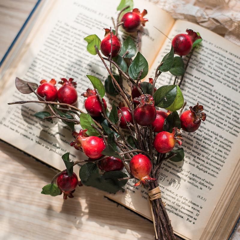 A vibrant 12-inch tall artificial pomegranate fruit bouquet featuring realistic red pomegranates and green leaves, perfect for home decor.