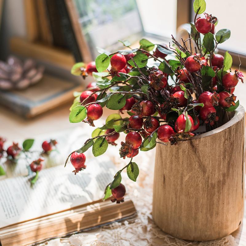 A vibrant 12-inch tall artificial pomegranate fruit bouquet featuring realistic red pomegranates and green leaves, perfect for home decor.