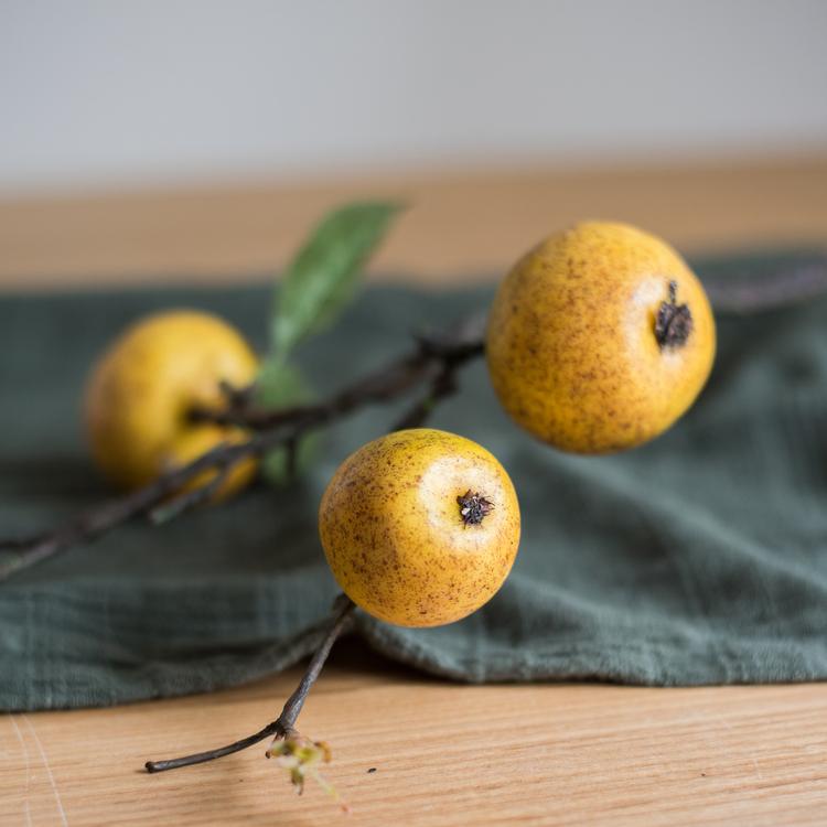 A 27-inch tall artificial fruit stem featuring four realistic yellow apple pears with green accents, perfect for home decor.