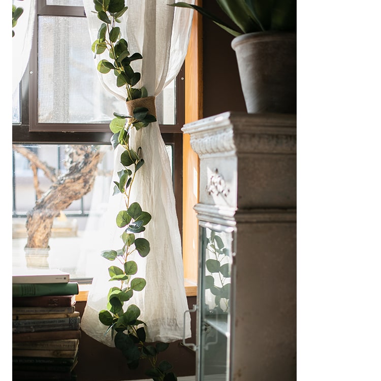 A long artificial green eucalyptus vine, 70 inches, with realistic silk leaves, perfect for home and event decor.