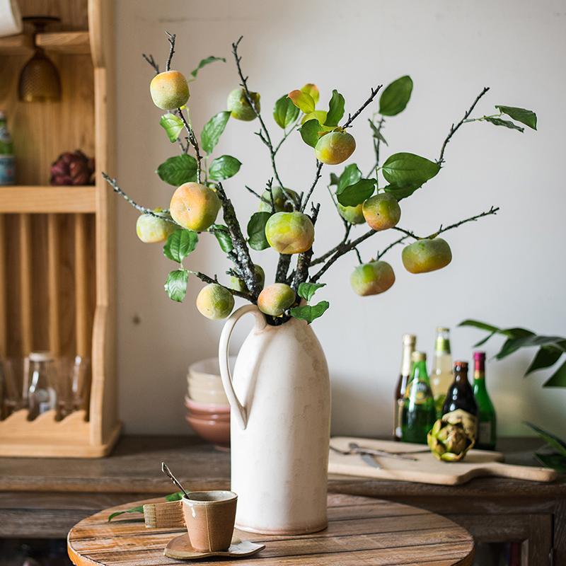 A tall artificial green persimmon fruit stem with four realistic fruits, showcasing vibrant green and yellow colors, perfect for home decor.