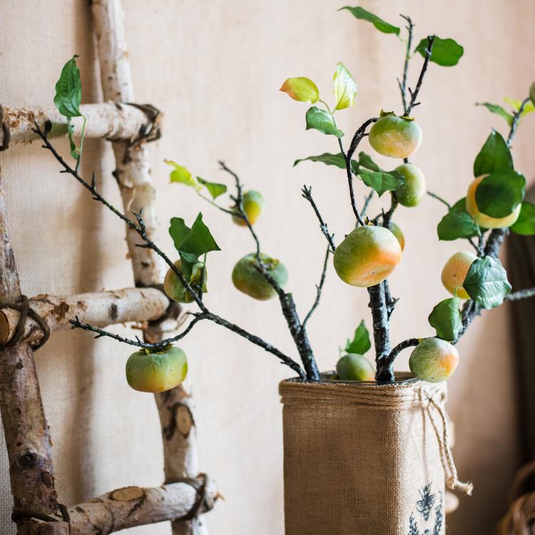 A tall artificial green persimmon fruit stem with four realistic fruits, showcasing vibrant green and yellow colors, perfect for home decor.