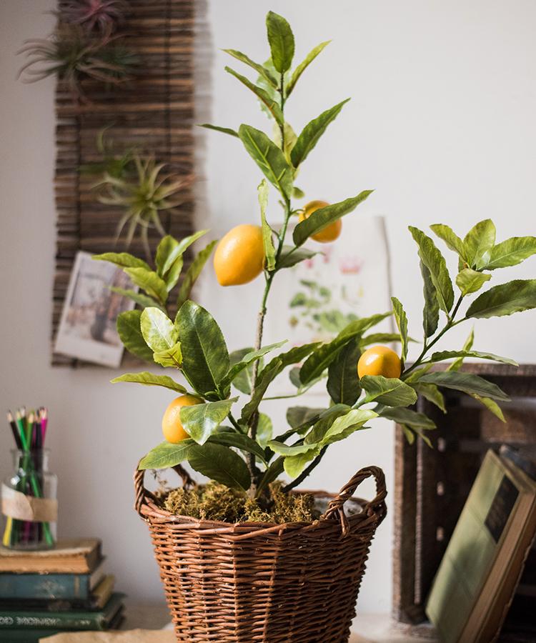 A realistic artificial lemon tree in a black pot, featuring vibrant green leaves and bright yellow lemons, perfect for home decor.