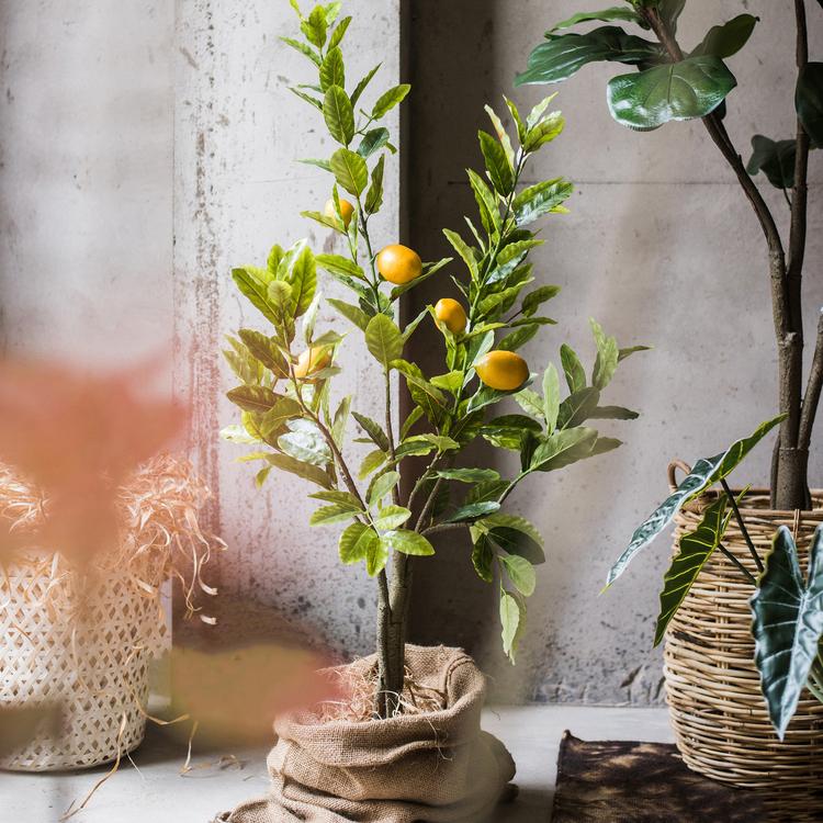 A realistic artificial lemon tree in a black pot, featuring vibrant green leaves and bright yellow lemons, perfect for home decor.