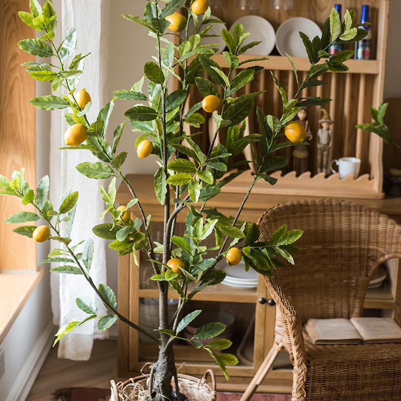 A realistic artificial lemon tree in a black pot, featuring vibrant green leaves and bright yellow lemons, perfect for home decor.