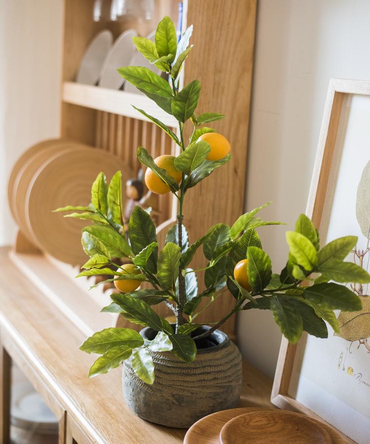 A realistic artificial lemon tree in a black pot, featuring vibrant green leaves and bright yellow lemons, perfect for home decor.