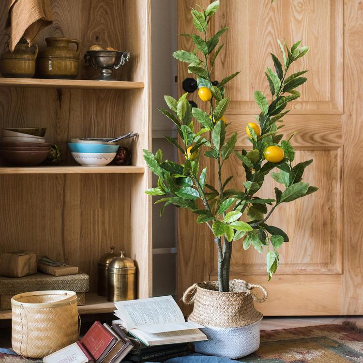 A realistic artificial lemon tree in a black pot, featuring vibrant green leaves and bright yellow lemons, perfect for home decor.