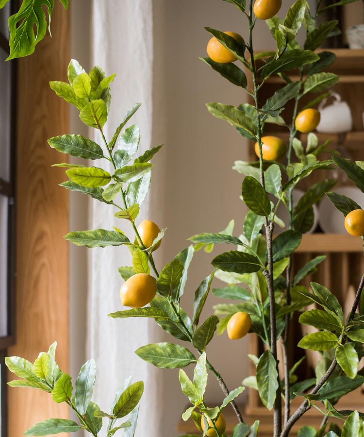 A realistic artificial lemon tree in a black pot, featuring vibrant green leaves and bright yellow lemons, perfect for home decor.