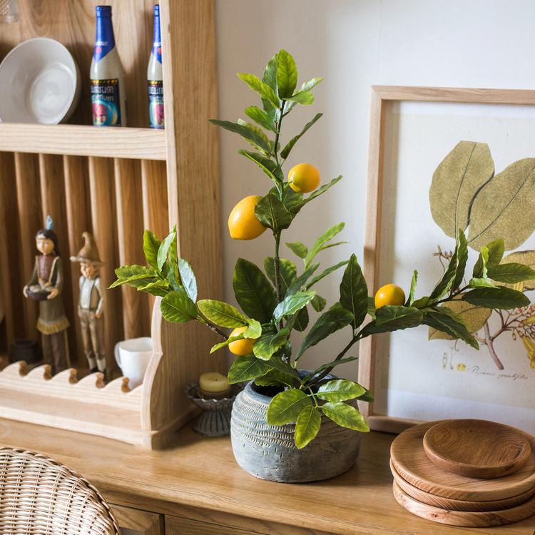 A realistic artificial lemon tree in a black pot, featuring vibrant green leaves and bright yellow lemons, perfect for home decor.