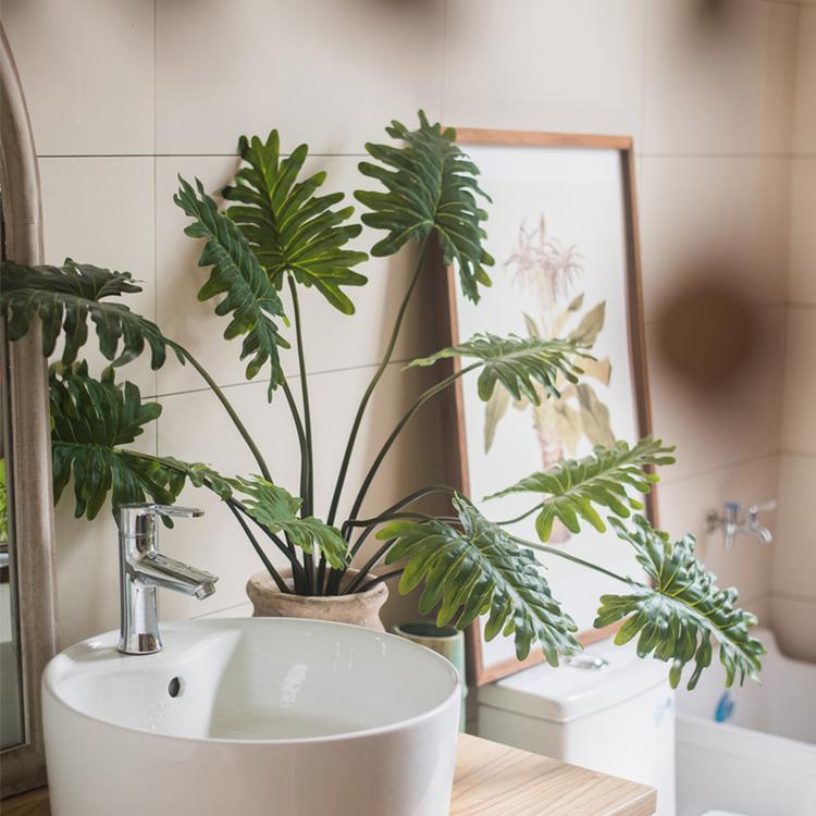 A 31-inch tall artificial Philodendron plant in a black pot, showcasing realistic green leaves and a lifelike appearance.