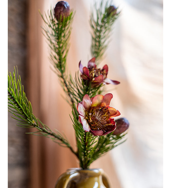 A 26-inch tall artificial pine needle flower stem in mixed colors, showcasing realistic details and vibrant hues.