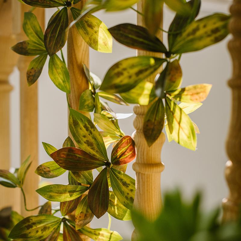 A long artificial vine with large brown and green leaves, measuring 69 inches, perfect for home decor.