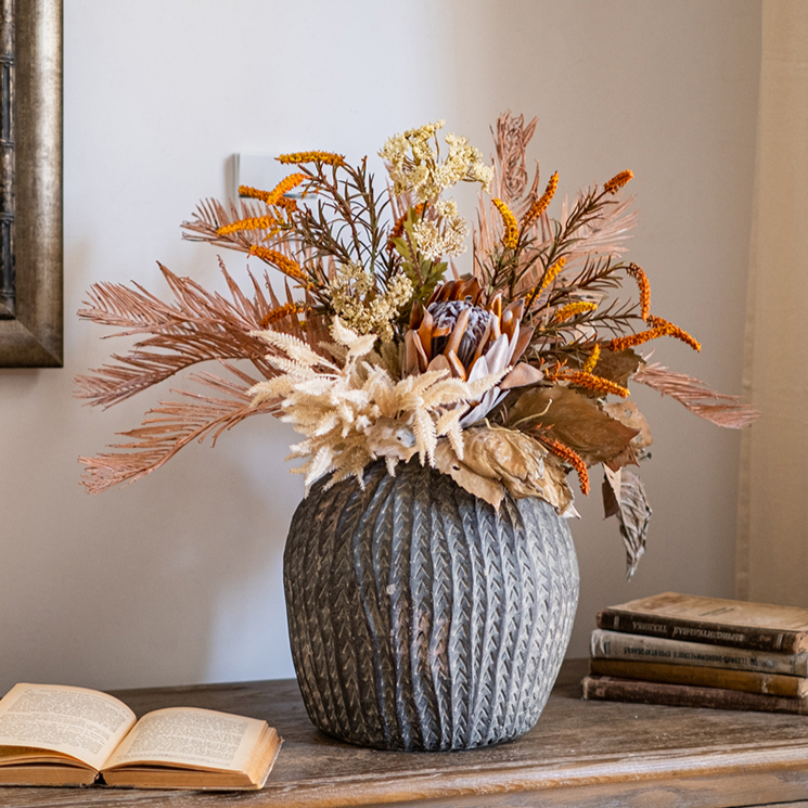 A beautifully arranged Artificial Silk Natural Fall Designer Flower Bouquet featuring protea and fern plants in white, purple, and light brown colors.