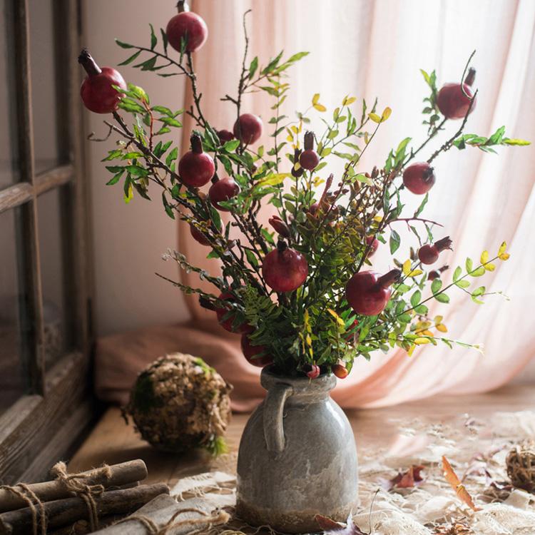 A vibrant 22-inch tall artificial silk bouquet featuring realistic red pomegranate fruits and lush green leaves, perfect for home decor.