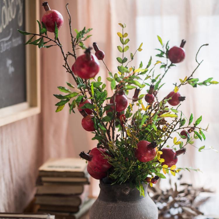 A vibrant 22-inch tall artificial silk bouquet featuring realistic red pomegranate fruits and lush green leaves, perfect for home decor.