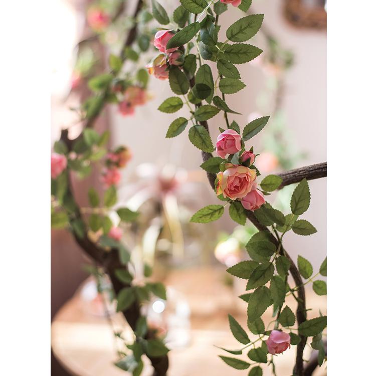 A 57-inch long artificial silk rose vine featuring small roses in pink, purple, white, and red, perfect for home decor.