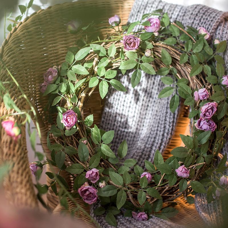 A 57-inch long artificial silk rose vine featuring small roses in pink, purple, white, and red, perfect for home decor.