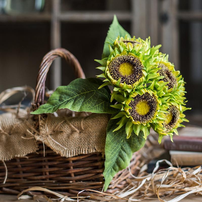 A vibrant artificial silk yellow sunflower bouquet, featuring seven flower stems with rich yellow petals and textured green leaves, standing 13 inches tall.