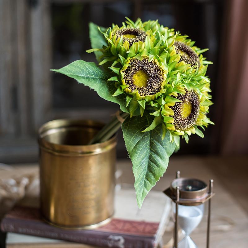 A vibrant artificial silk yellow sunflower bouquet, featuring seven flower stems with rich yellow petals and textured green leaves, standing 13 inches tall.