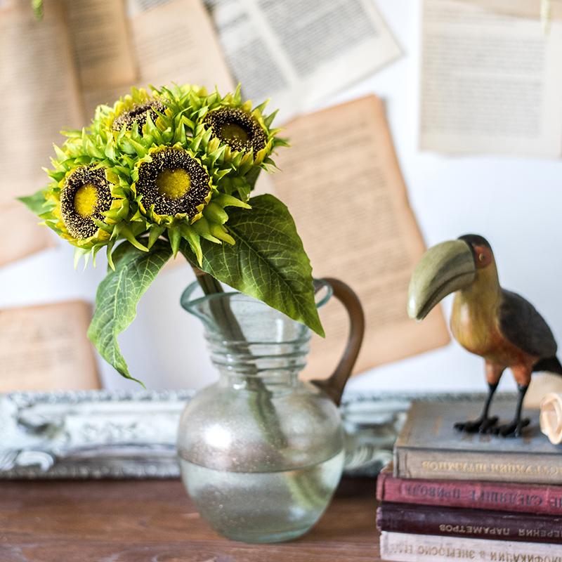 A vibrant artificial silk yellow sunflower bouquet, featuring seven flower stems with rich yellow petals and textured green leaves, standing 13 inches tall.