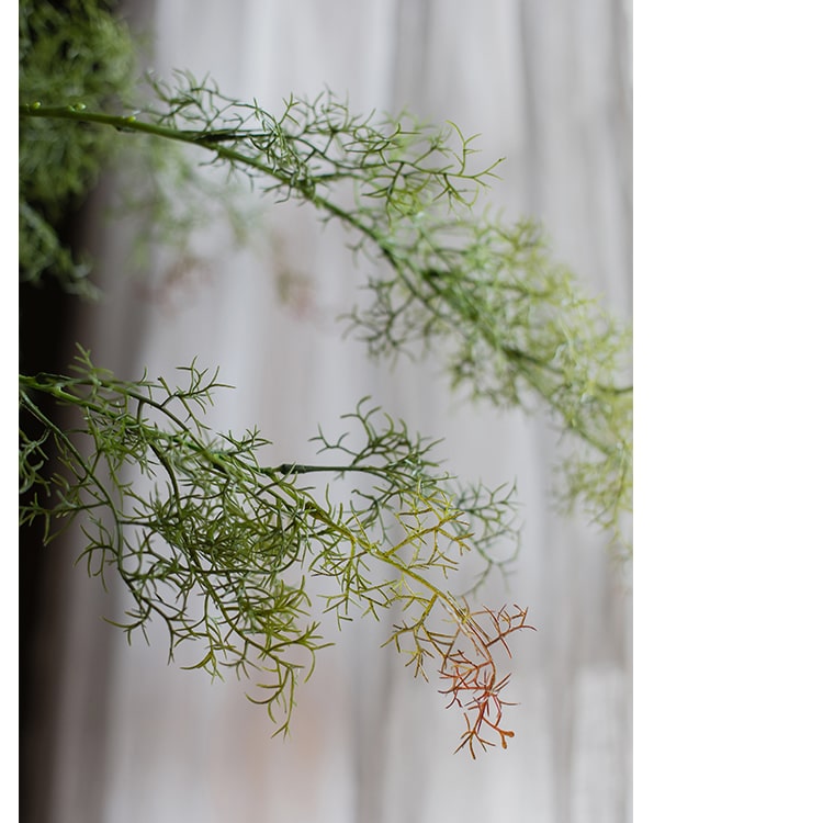 A tall 43-inch Artificial Siwu Grass Stem in vibrant green colors, showcasing realistic silk leaves and a lifelike appearance, perfect for home decor.