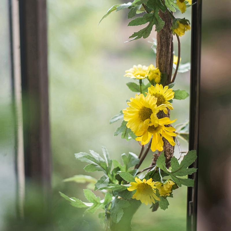 A long artificial sunflower vine featuring vibrant yellow sunflowers and lush green leaves, perfect for home decor.