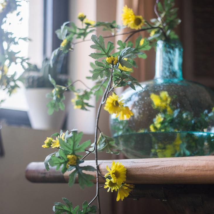 A long artificial sunflower vine featuring vibrant yellow sunflowers and lush green leaves, perfect for home decor.