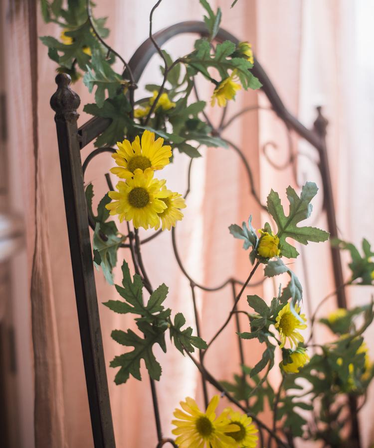 A long artificial sunflower vine featuring vibrant yellow sunflowers and lush green leaves, perfect for home decor.