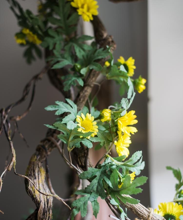 A long artificial sunflower vine featuring vibrant yellow sunflowers and lush green leaves, perfect for home decor.