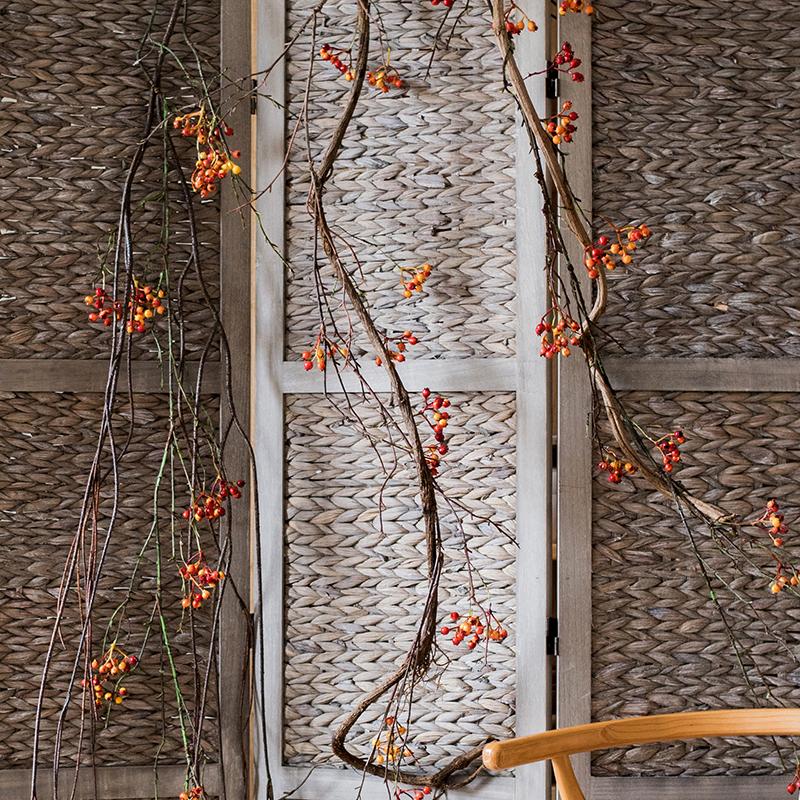 A 39-inch long artificial vine featuring vibrant orange faux berries and brown accents, perfect for home decor.