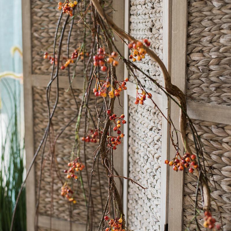 A 39-inch long artificial vine featuring vibrant orange faux berries and brown accents, perfect for home decor.