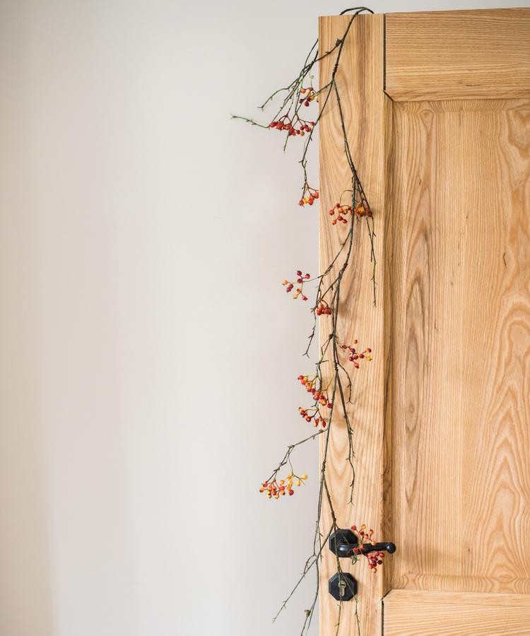 A 39-inch long artificial vine featuring vibrant orange faux berries and brown accents, perfect for home decor.