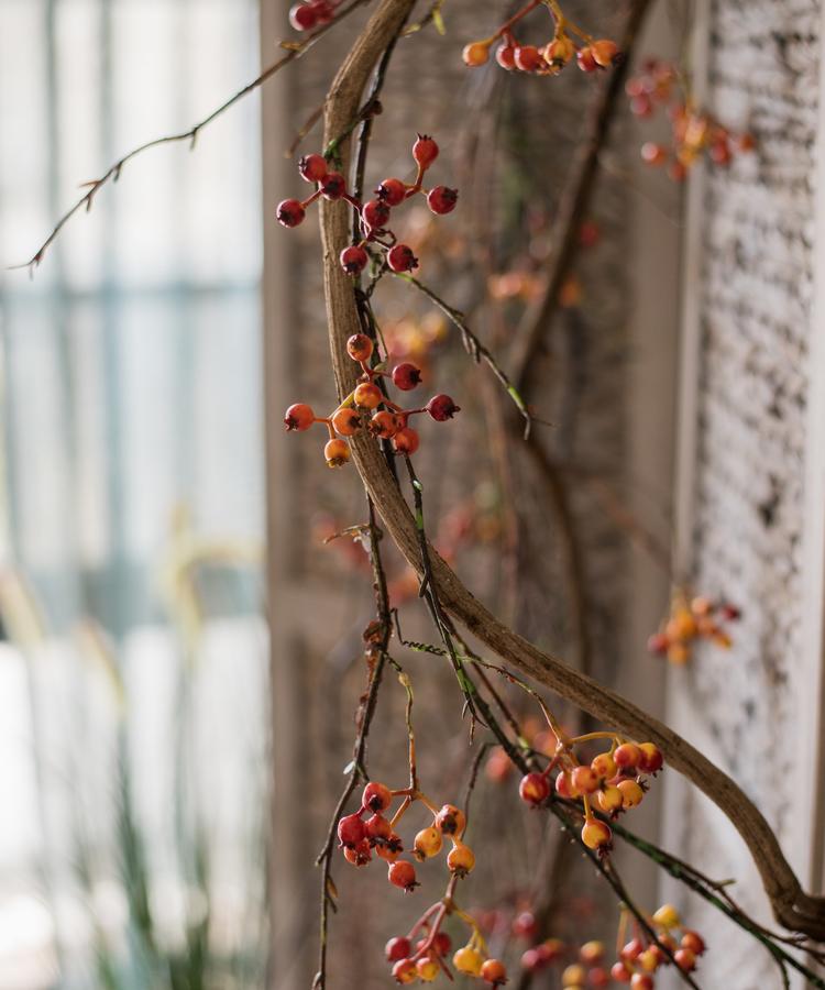 A 39-inch long artificial vine featuring vibrant orange faux berries and brown accents, perfect for home decor.