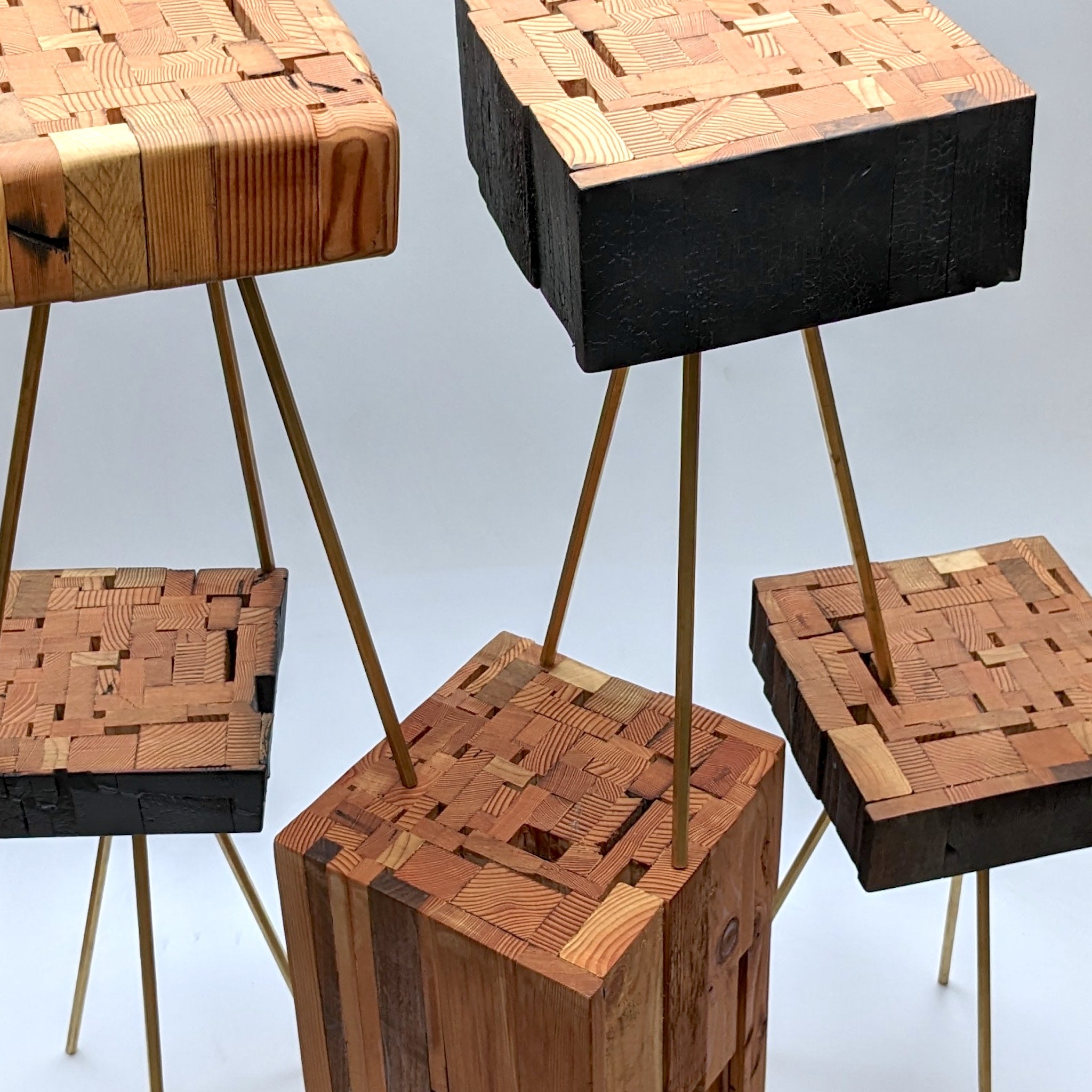 Assemblage side table made from salvaged wood with brass hexagon legs, showcasing unique design and craftsmanship.