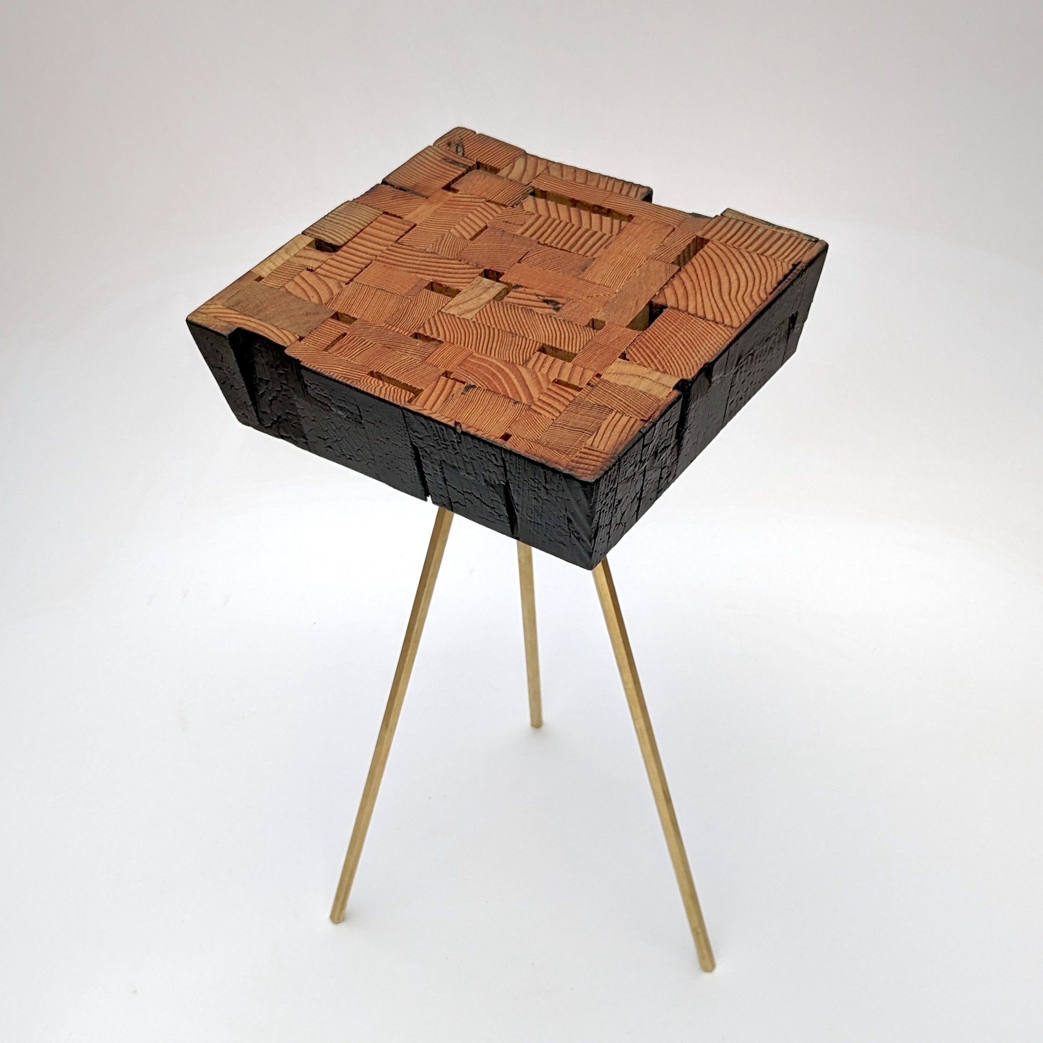 Assemblage side table made from salvaged wood with brass hexagon legs, showcasing unique design and craftsmanship.