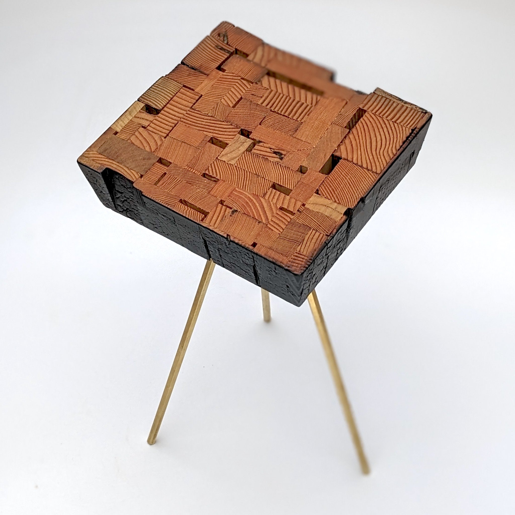 Assemblage side table made from salvaged wood with brass hexagon legs, showcasing unique design and craftsmanship.