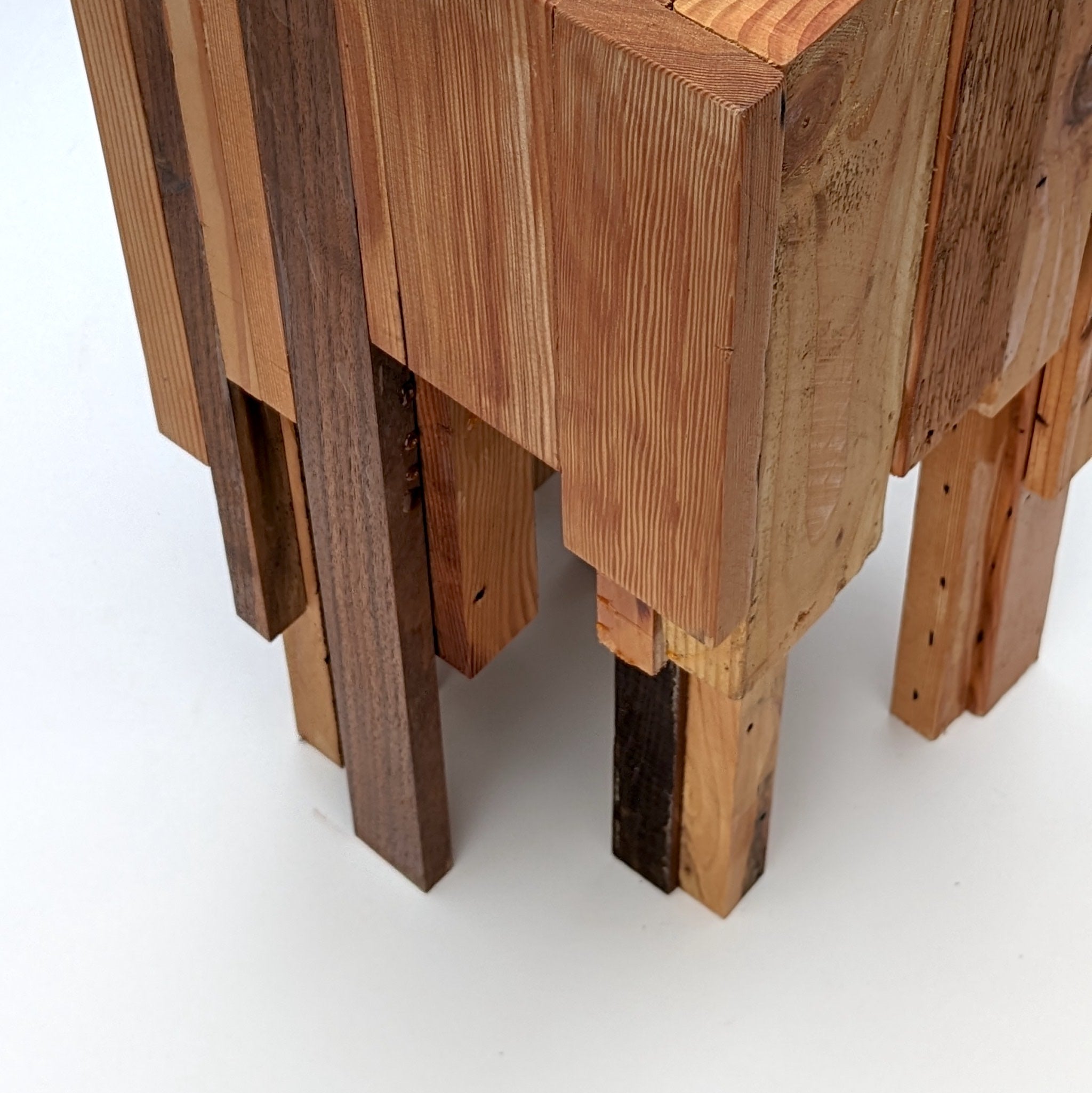 Assemblage side table made from salvaged wood with brass hexagon legs, showcasing unique design and craftsmanship.