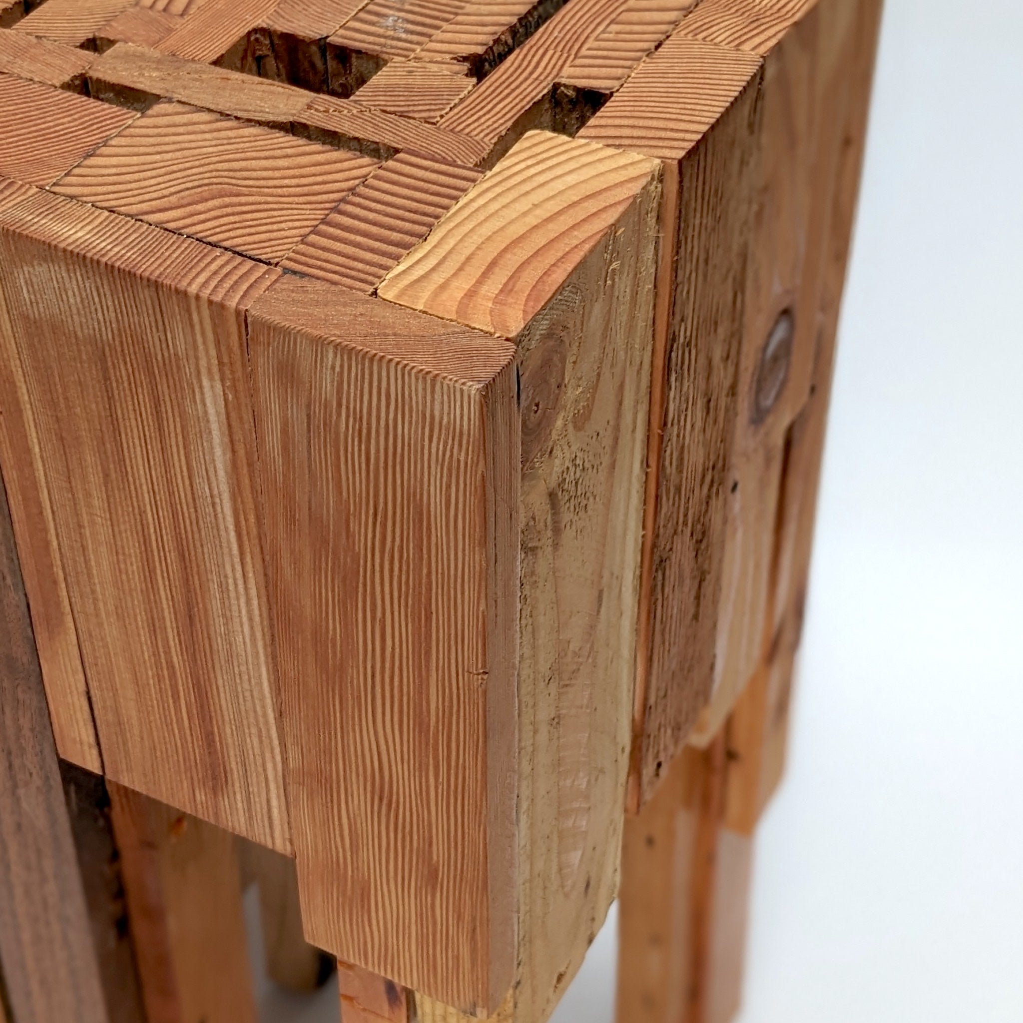 Assemblage side table made from salvaged wood with brass hexagon legs, showcasing unique design and craftsmanship.