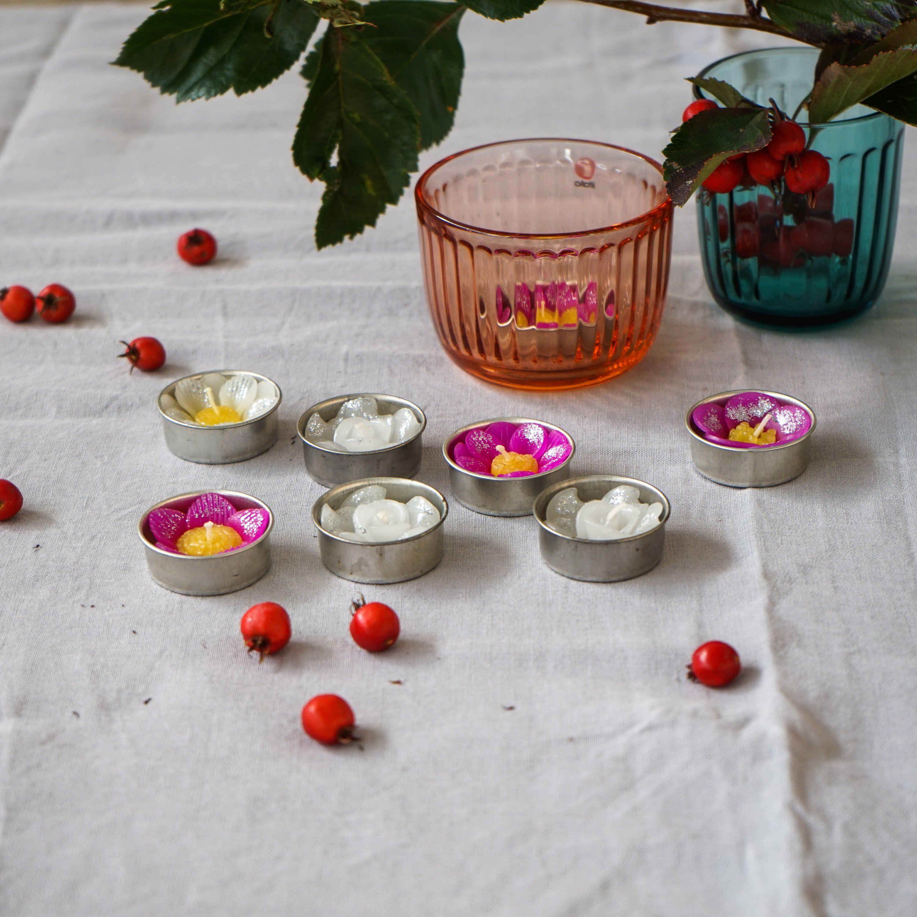 A collection of assorted glitter flower scented tealights in white, pink, and yellow, beautifully arranged in a botanic garden printed box.