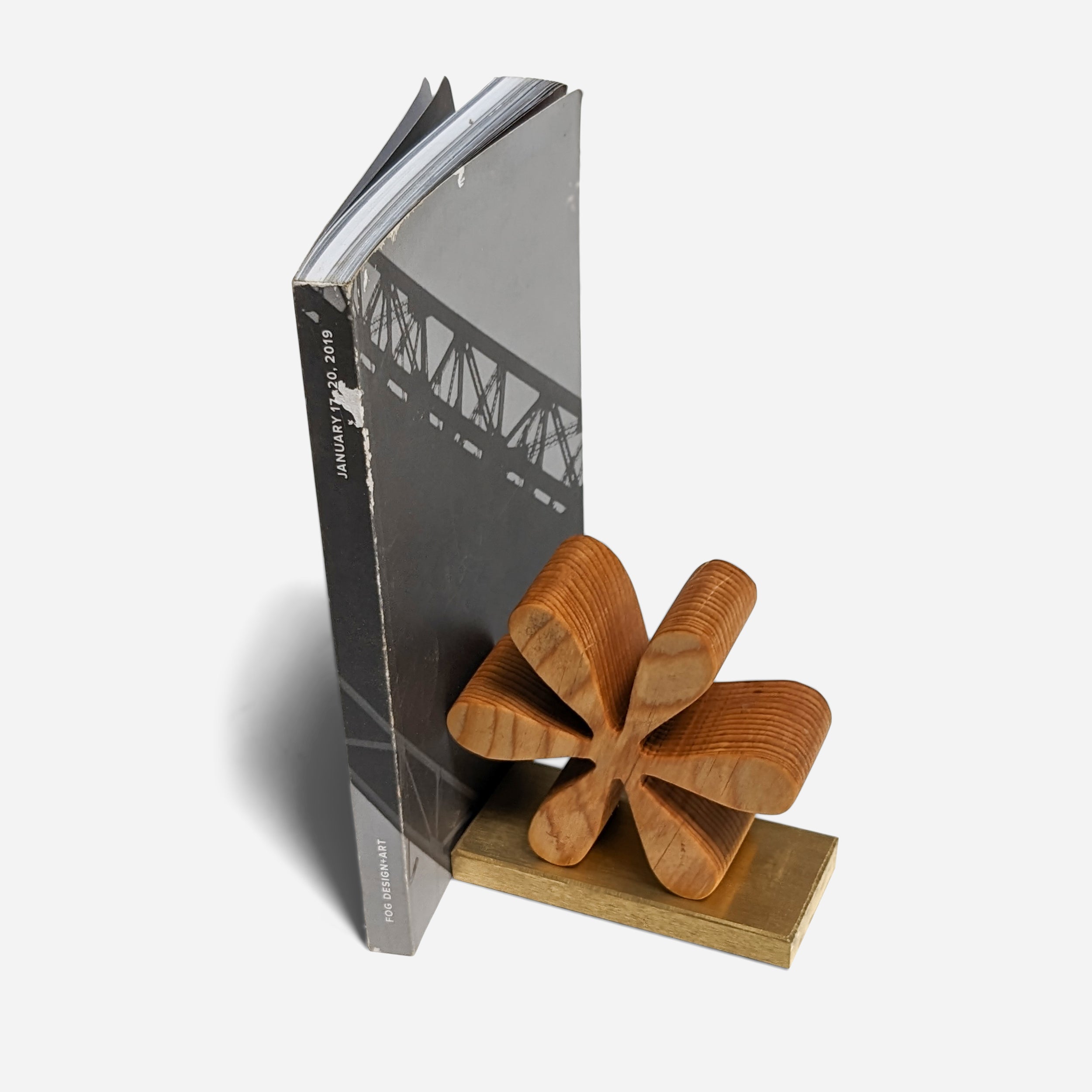 Asterisk bookends made of reclaimed wood with a natural finish, showcasing unique color variations and elegant brass accents.