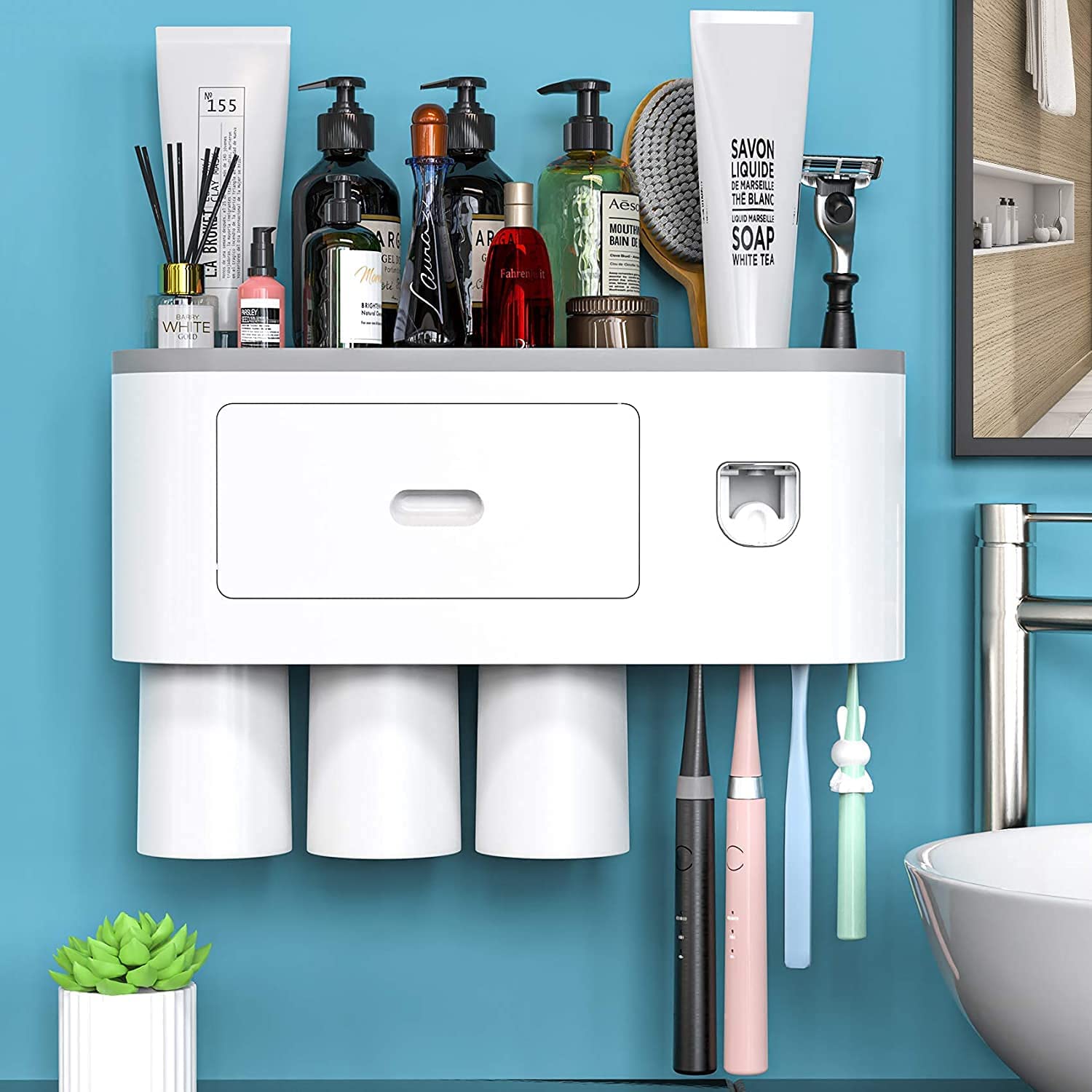 Automatic wall mounted toothbrush holder with magnetic cups in white and gray, designed for kids and families, featuring a toothpaste dispenser and storage tray.