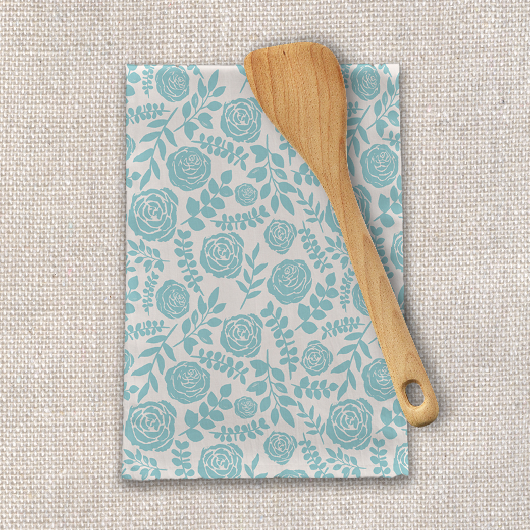 A soft cotton twill tea towel featuring a charming baby blue floral design, perfect for kitchen use and decor.