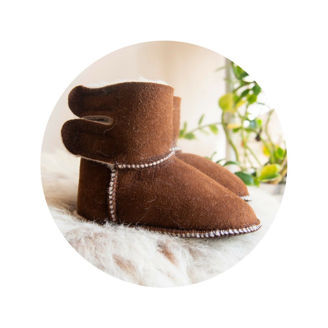 A pair of handmade baby brown sheepskin boots with soft fur lining, designed for comfort and warmth.