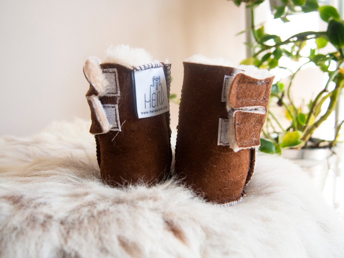 A pair of handmade baby brown sheepskin boots with soft fur lining, designed for comfort and warmth.