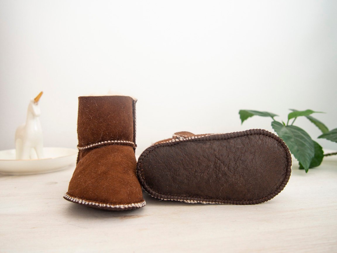 A pair of handmade baby brown sheepskin boots with soft fur lining, designed for comfort and warmth.